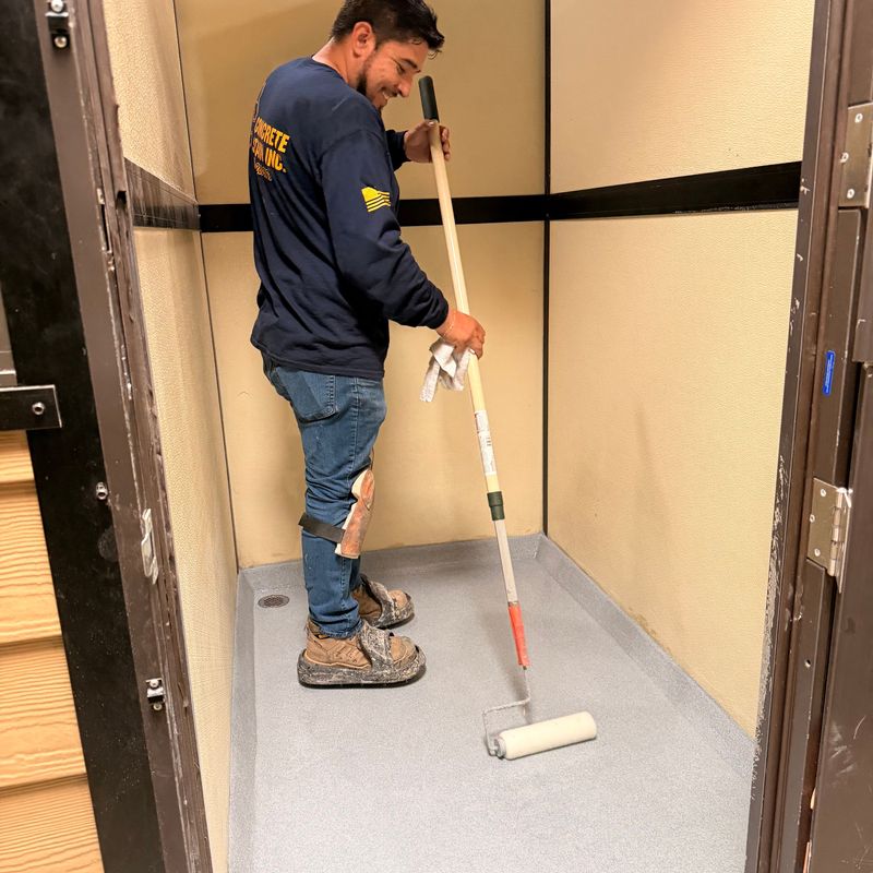 A worker seals the floor inside a rebuilt kennel