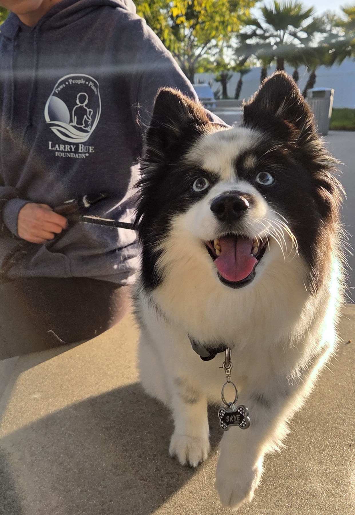 Skye smiles beside a Larry Blue Foundation volunteer